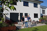 STREIF-Bauberater Thum (links) überreicht Baufamilie Jungbauer einen Präsentkorb zur Auszeichnung mit dem Deutschen Traumhauspreis in Silber 2020