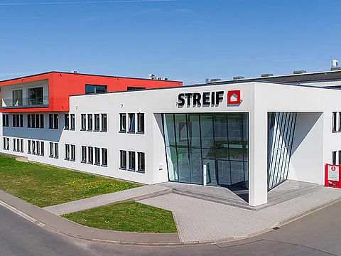 STREIF Unternehmensgebäude mit weißer Fassade, rotem Obergeschoss und verglastem Eingangsbereich