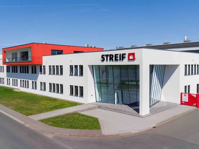 STREIF Unternehmensgebäude mit weißer Fassade, rotem Obergeschoss und verglastem Eingangsbereich
