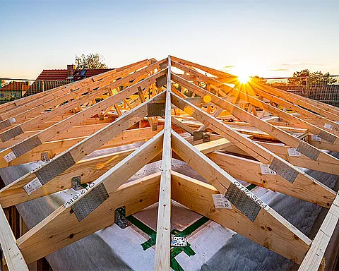 Baustelle Dachstuhl aus Holz bei Sonnenuntergang in erhöhter Perspektive