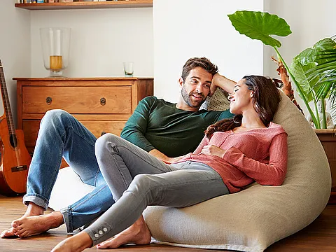 STREIF Innenraum Paar entspannt barfuß auf Sitzsack im Wohnzimmer mit Fußbodenheizung