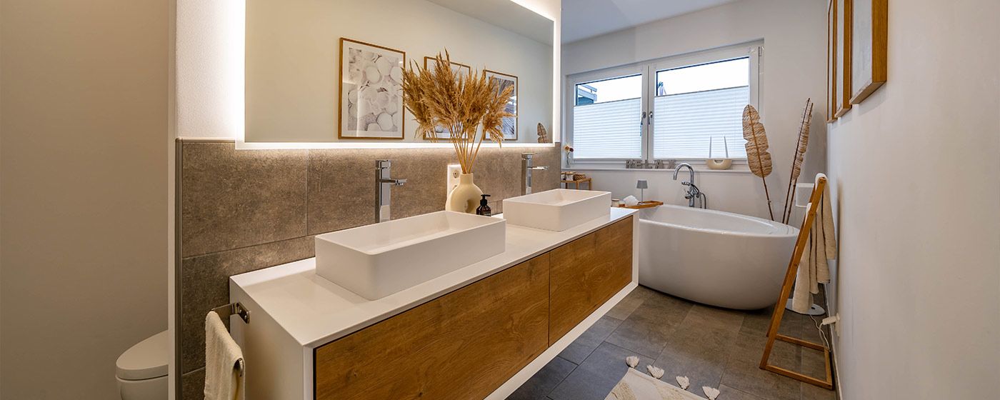 mediterranes Bad mit hellen Fliesen, Holz und runder Badewanne