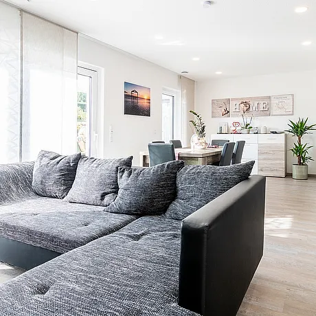 Modernes offenes Wohnzimmer mit Essbereich im Fertighaus von STREIF lichtdurchflutet hochwertig und zeitlos gestaltet