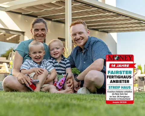 STREIF Baufamilie sitzt im Sommer vor einer modernen Stadtvilla mit Terrassenüberdachung