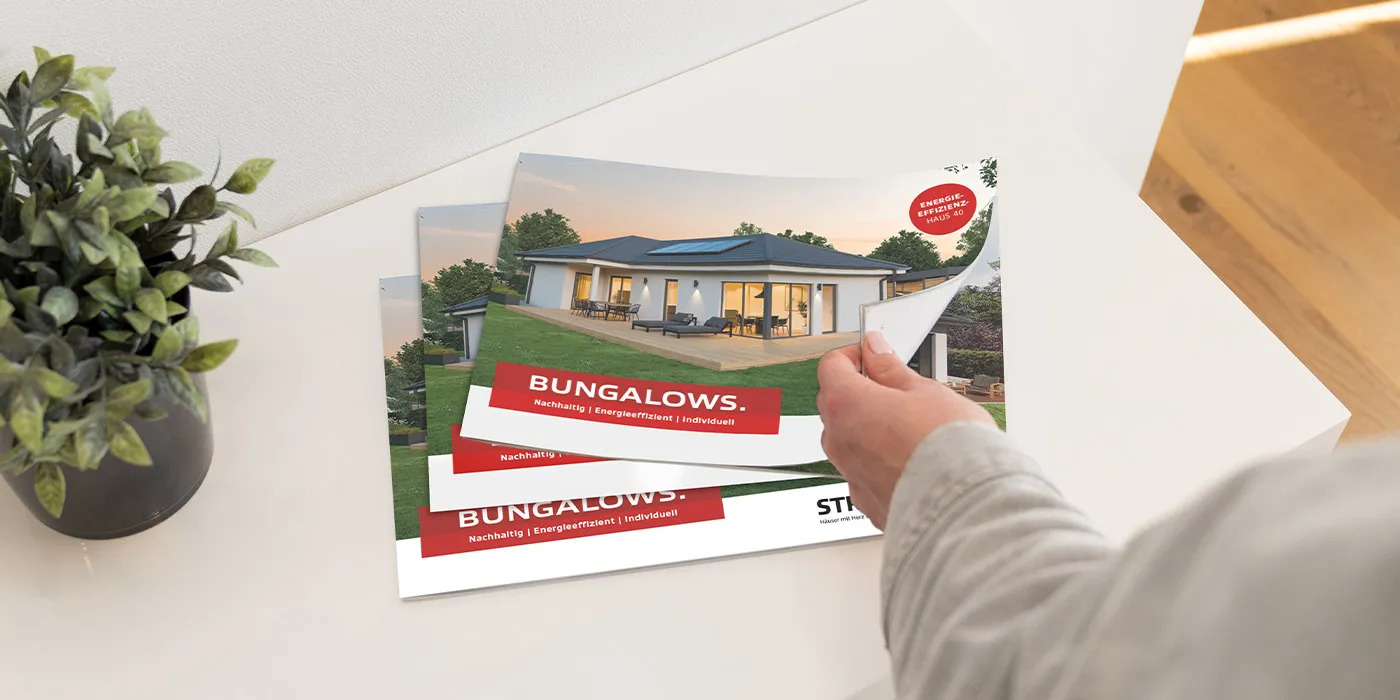 STREIF Katalog Bungalows auf weißem Tisch mit Hand beim Umblättern