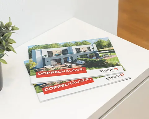 Gedrucktes Prospekt mit STREIF-Doppelhäusern auf weißem Schrank