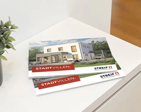 STREIF-Prospekt über Stadtvillen liegt auf weißem Sidboard