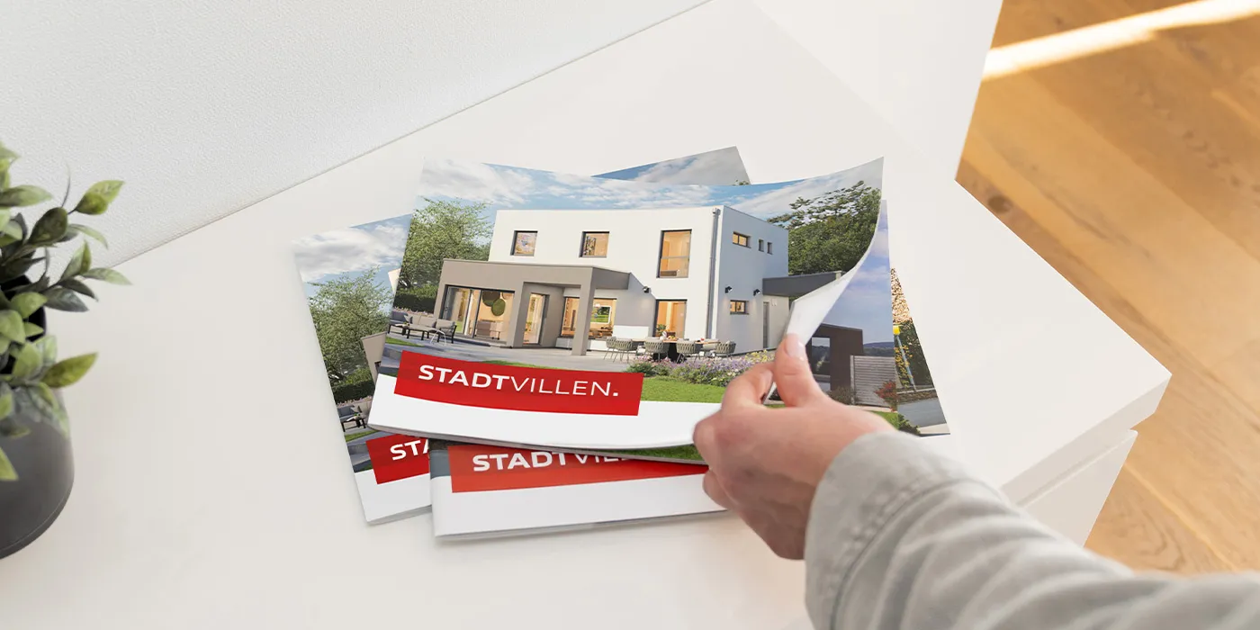 STREIF Katalog Stadtvilla mit Hausmotiv auf Tisch und Hand beim Umblättern