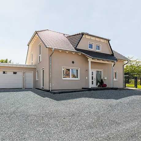 Fertighaus Einfamilienhaus mit Satteldach, Garage und gepflasterter Einfahrt in Außenansicht