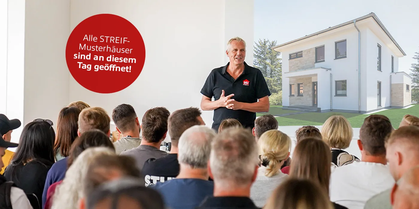STREIF Geschäftsführer präsentiert vor Publikum mit projizierter Stadtvilla und Hinweis auf geöffneten Aktionstag