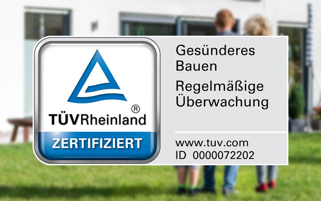 TÜV Rheinland Zertifikat Logo mit Hinweis auf gesundes Bauen und regelmäßige Überwachung vor Wohnhaus